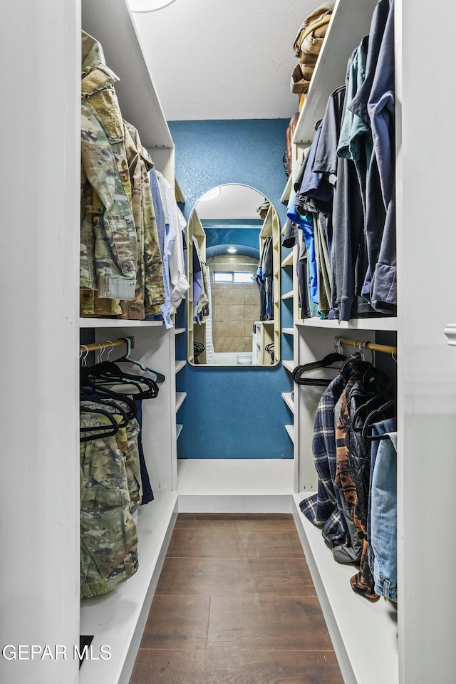 walk in closet with dark hardwood / wood-style flooring