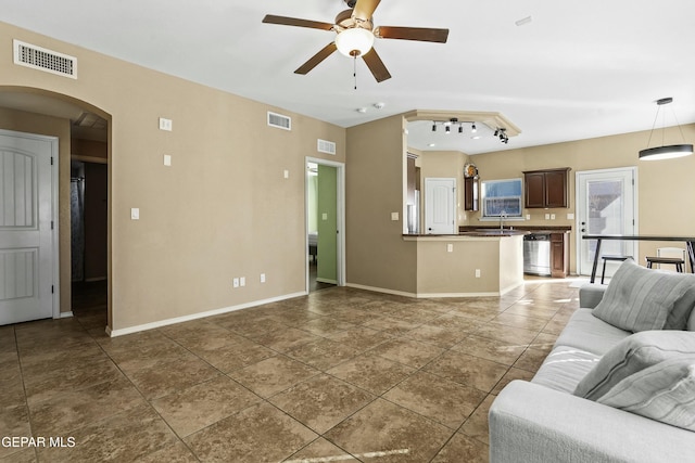 tiled living room featuring ceiling fan and sink