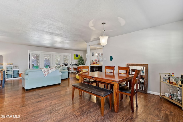 dining room with french doors, dark hardwood / wood-style floors, and a textured ceiling