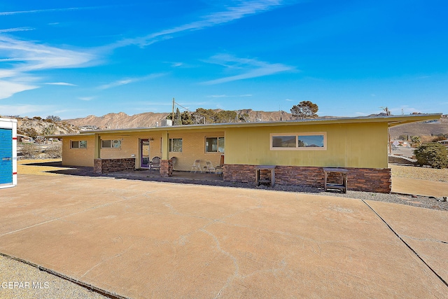 rear view of house with a mountain view and a patio area