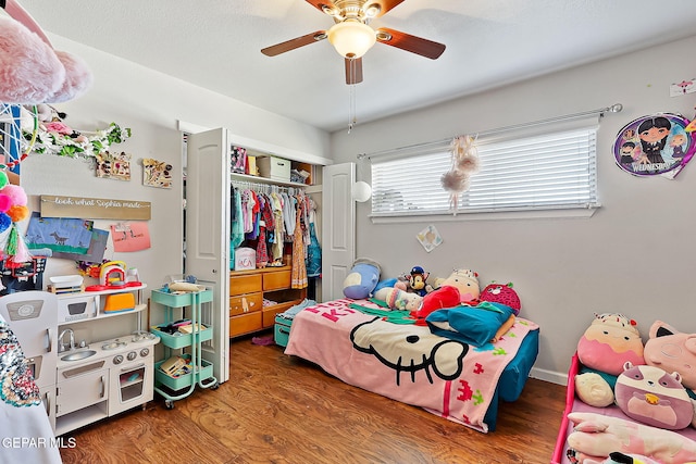 bedroom featuring hardwood / wood-style flooring, a textured ceiling, ceiling fan, and a closet