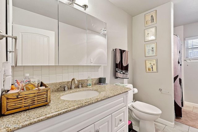 bathroom with vanity, backsplash, tile patterned floors, and toilet