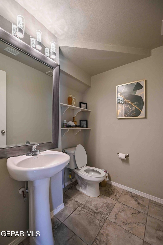 1009 Earthstar Pl, El Paso, TX 79928 - bathroom with toilet, a textured ceiling, visible vents, and baseboards