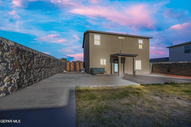 1009 Earthstar Pl, El Paso, TX 79928 - back of property at dusk with stucco siding, a patio, and a fenced backyard