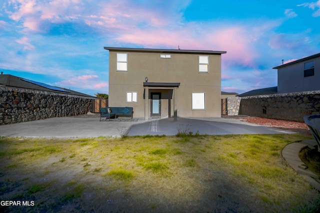 1009 Earthstar Pl, El Paso, TX 79928 - back of house at dusk with a patio area, a fenced backyard, a yard, and stucco siding