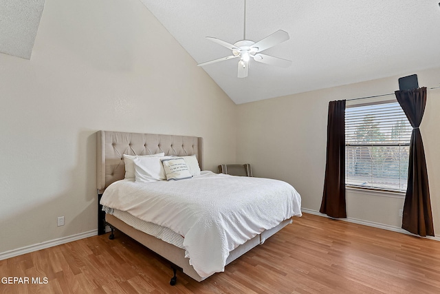 bedroom with lofted ceiling, ceiling fan, a textured ceiling, wood finished floors, and baseboards