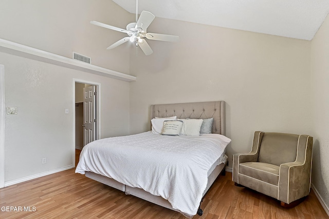 bedroom with wood finished floors, a ceiling fan, visible vents, vaulted ceiling, and baseboards