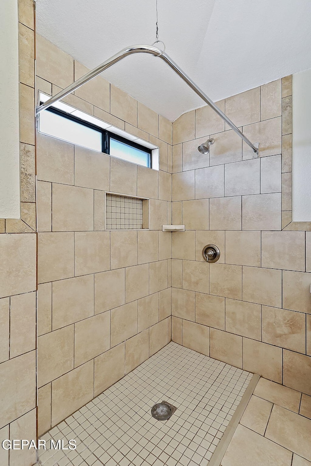 full bath with a tile shower