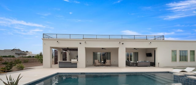 back of property with an outdoor kitchen, outdoor lounge area, a ceiling fan, stucco siding, and a patio area