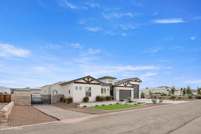 view of front of house featuring a garage, concrete driveway, a fenced front yard, and a residential view