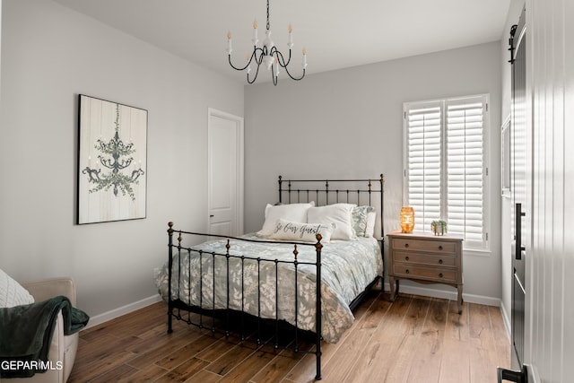 bedroom with multiple windows, wood finished floors, and baseboards