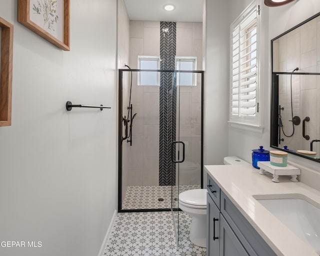 full bath with toilet, a shower stall, baseboards, and vanity