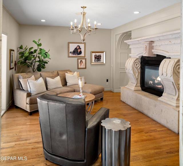 living area featuring baseboards, recessed lighting, a fireplace, and light wood-style floors