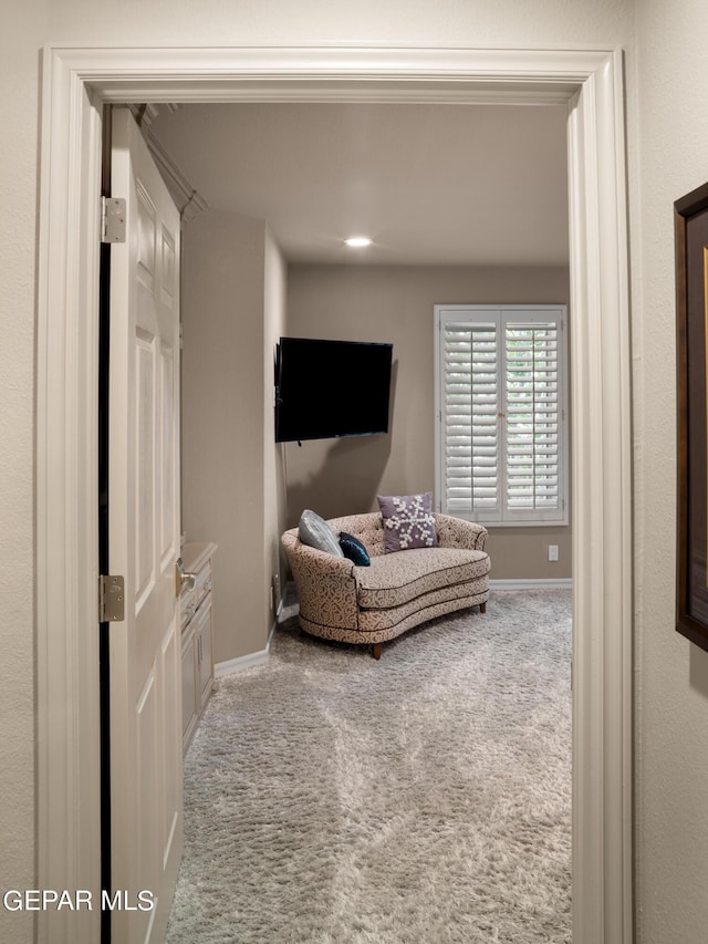 sitting room featuring baseboards and carpet flooring