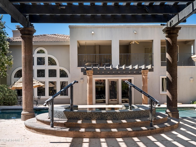 back of house with a patio, a tile roof, a balcony, and stucco siding