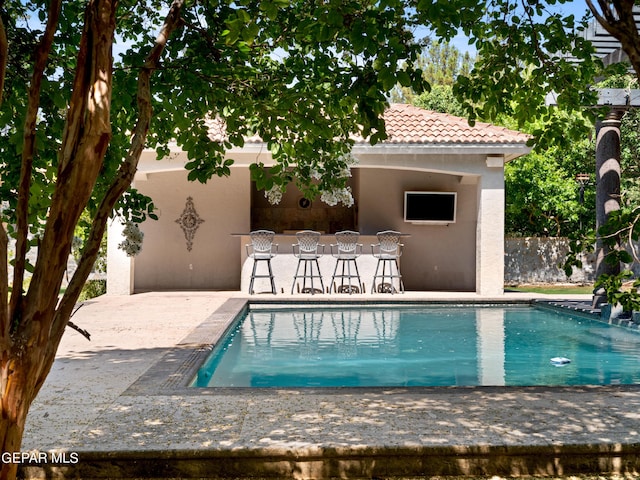 pool featuring outdoor dry bar, a patio, and fence