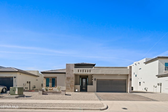 view of front of property featuring a garage and central AC unit