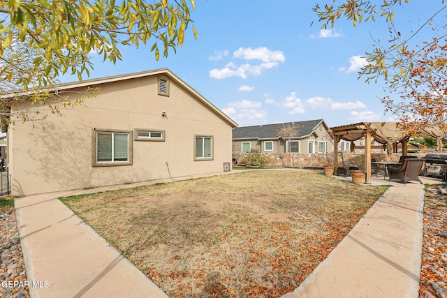 rear view of property featuring a lawn, a patio area, and a pergola