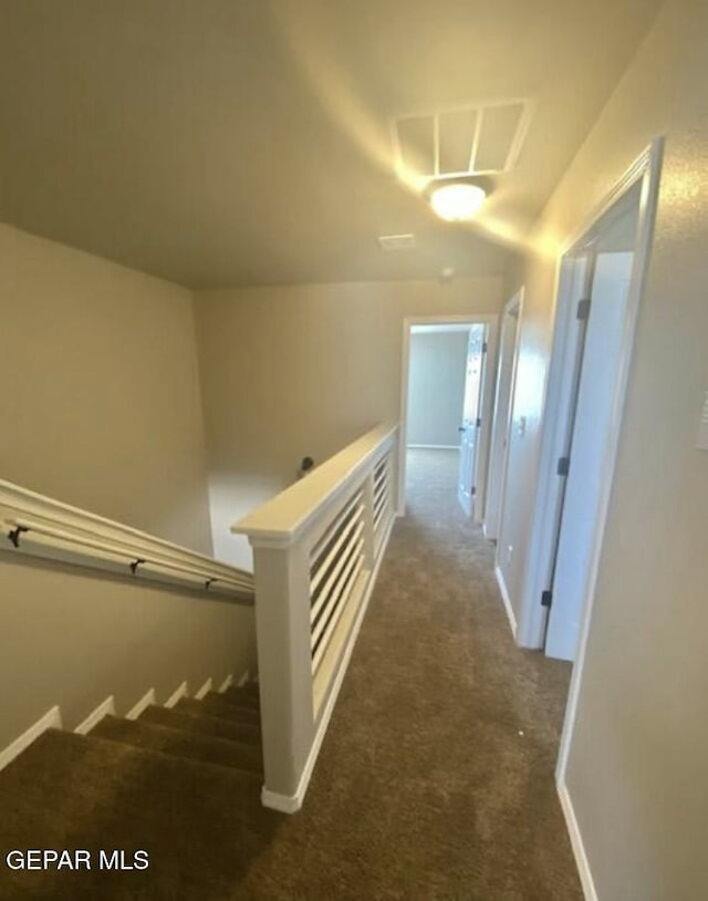 hallway featuring dark colored carpet