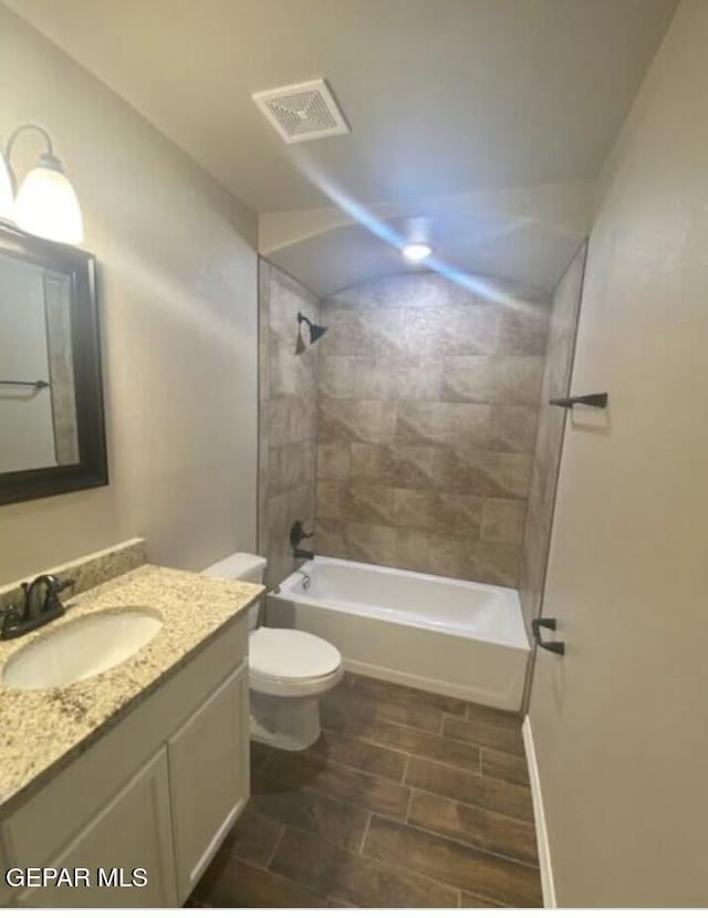 full bathroom with vanity, tiled shower / bath combo, and toilet