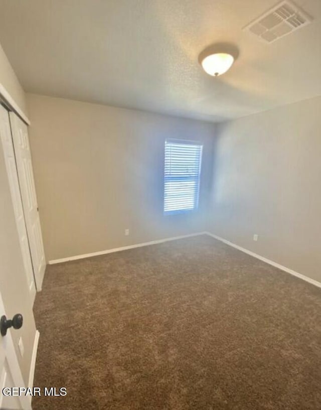 unfurnished bedroom with dark colored carpet