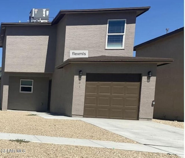 view of front of property with a garage and central air condition unit