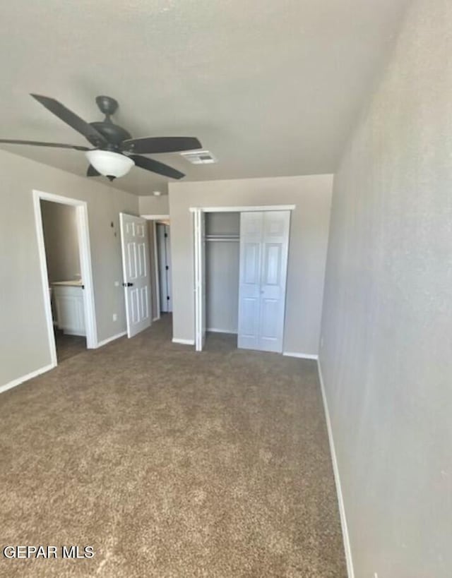 unfurnished bedroom with dark carpet, ceiling fan, and a closet