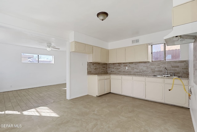 kitchen with tasteful backsplash, ceiling fan, and sink