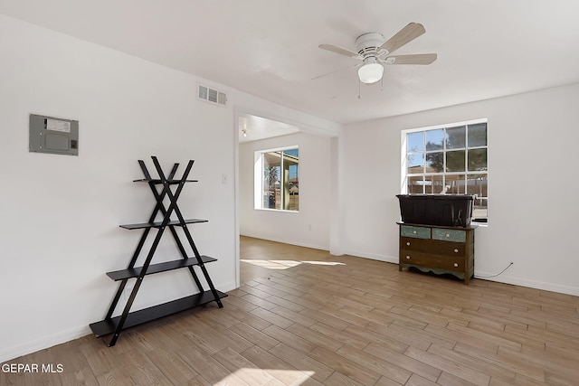 empty room with ceiling fan, a healthy amount of sunlight, and light wood-type flooring