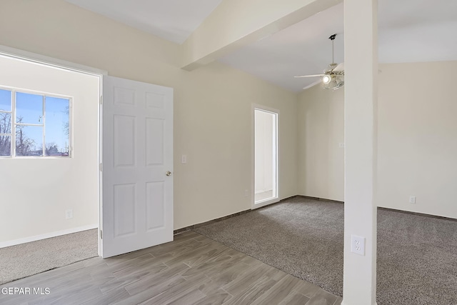 spare room featuring lofted ceiling, light carpet, and ceiling fan