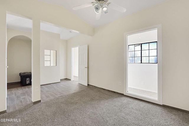 carpeted spare room featuring lofted ceiling and ceiling fan