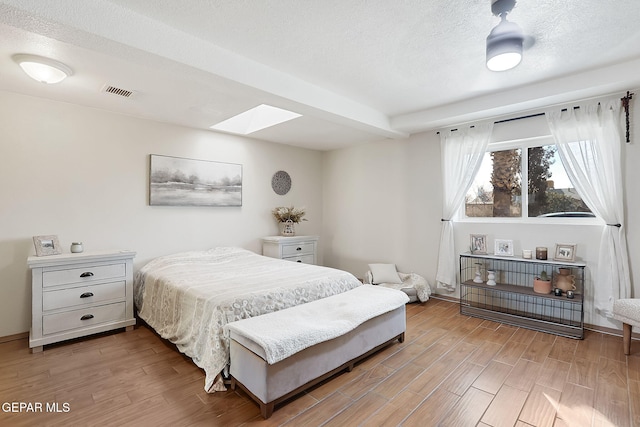 bedroom with a skylight and a textured ceiling