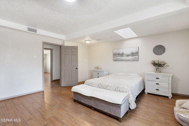 bedroom with a skylight and a textured ceiling