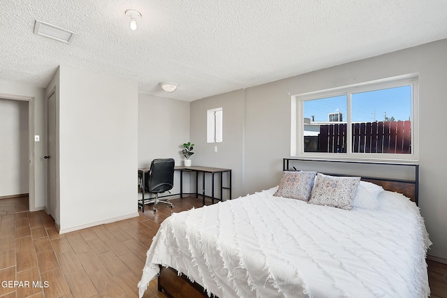 bedroom featuring hardwood / wood-style floors and a textured ceiling