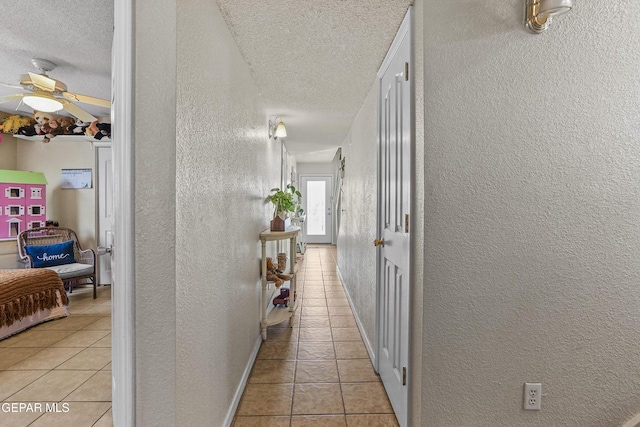 hallway with light tile patterned flooring and a textured ceiling