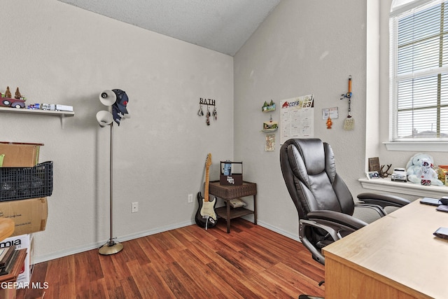 office space featuring vaulted ceiling, wood-type flooring, and a healthy amount of sunlight