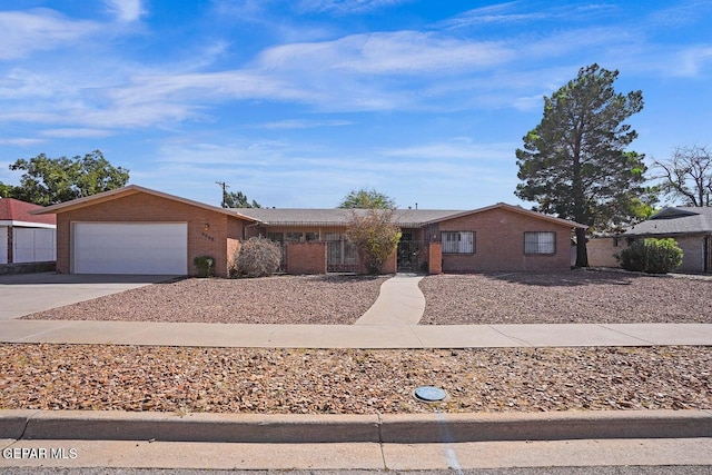 single story home featuring brick siding, fence, a garage, and concrete driveway