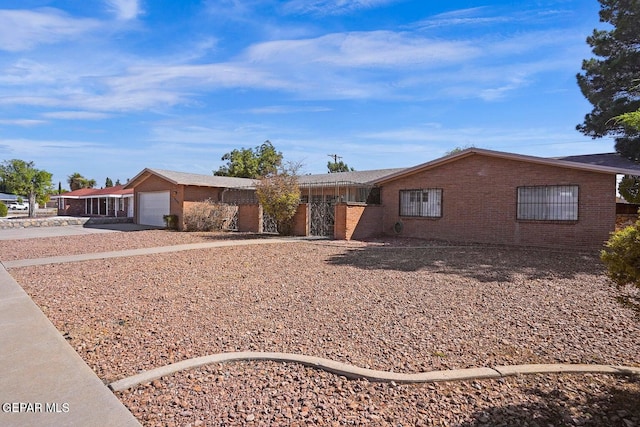 ranch-style house featuring brick siding, driveway, and an attached garage
