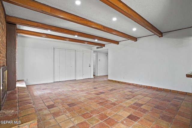 unfurnished living room featuring baseboards, recessed lighting, a fireplace, a textured ceiling, and beam ceiling