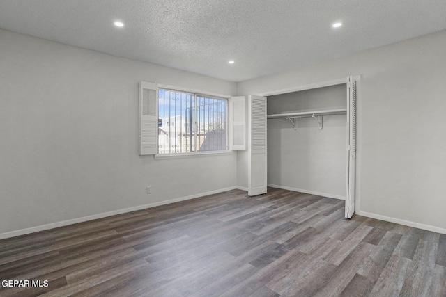 unfurnished bedroom featuring a textured ceiling, a closet, recessed lighting, wood finished floors, and baseboards