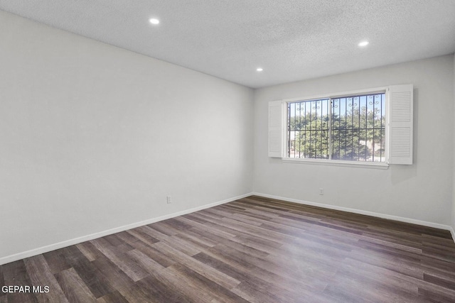 spare room featuring baseboards, recessed lighting, wood finished floors, and a textured ceiling