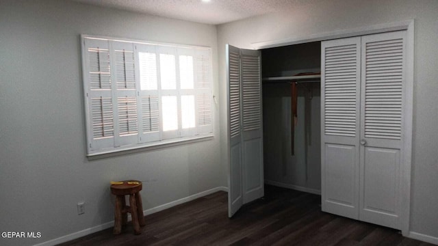 8808 Cosmos Ave, El Paso, TX 79925 - unfurnished bedroom with dark wood finished floors, a closet, baseboards, and a textured ceiling
