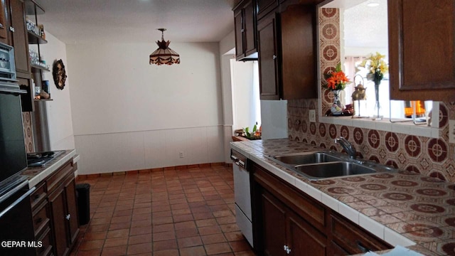 8808 Cosmos Ave, El Paso, TX 79925 - kitchen with tile counters, a sink, decorative backsplash, dark brown cabinetry, and hanging light fixtures