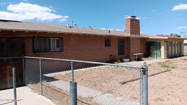 8808 Cosmos Ave, El Paso, TX 79925 - rear view of house featuring brick siding and a chimney