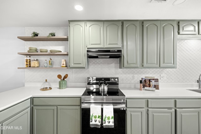 kitchen featuring stainless steel range with electric stovetop, sink, decorative backsplash, and green cabinetry