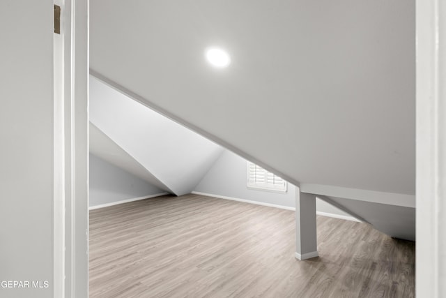 bonus room with lofted ceiling and light hardwood / wood-style floors