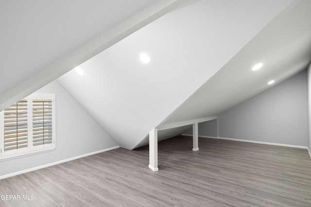 additional living space with wood-type flooring and lofted ceiling