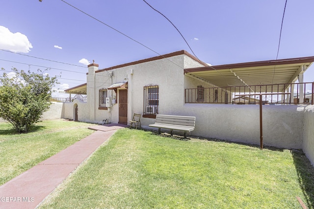 rear view of house featuring a lawn