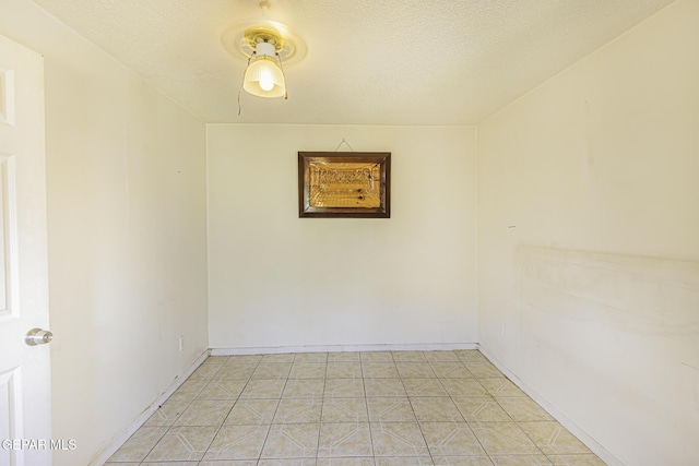 unfurnished room with a textured ceiling