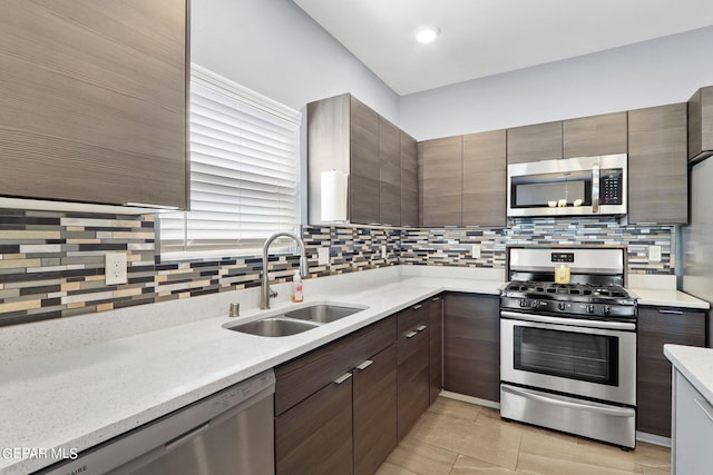 kitchen with light tile patterned flooring, appliances with stainless steel finishes, sink, and decorative backsplash